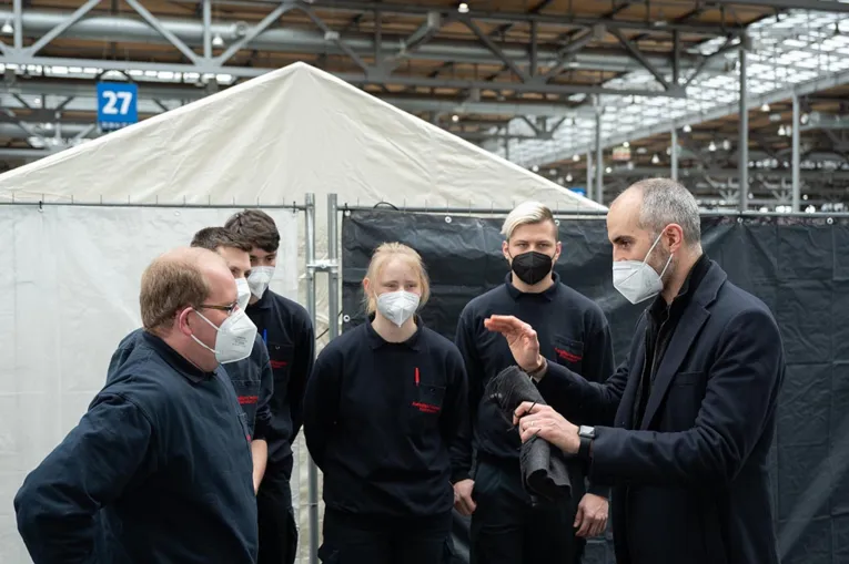 Oberb&uuml;rgermeister Belit Onay im Gespr&auml;ch mit Helfer*innen von der Feuerwehr.